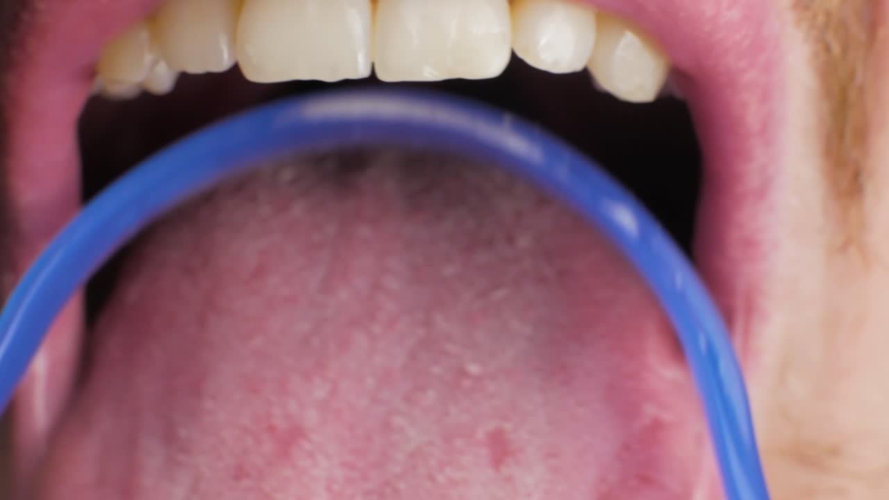using a tongue cleaner CLOSE UP