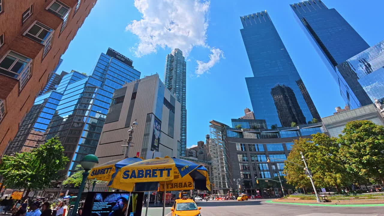 New York, USA, 1 August 2025: Modern towers of New York under bright blue sky. Tall skyscrapers of Manhattan rise high above Columbus Circle on a sunny day