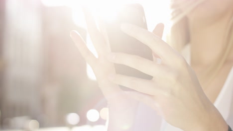 Hermosa-Mujer-Rubia-Usando-El-Concepto-De-Energía-Solar-De-La-Luz-Solar-De-La-Llamarada-Del-Teléfono-Inteligente