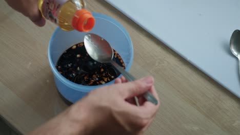adding bottled rice wine to soy sauce marinade in a plastic container. -closeup shot