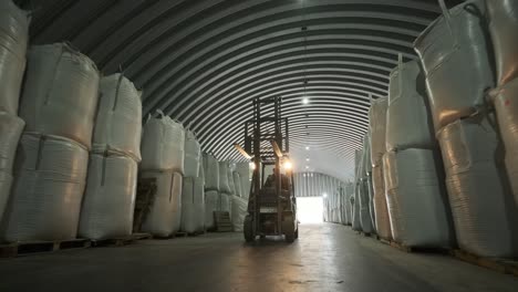 warehousing. forklift driver stacking big bag of raw material in warehouse. 
many bags of raw materials in the warehouse