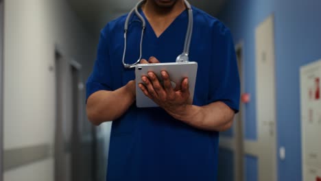 médico usando una tableta en el pasillo del hospital