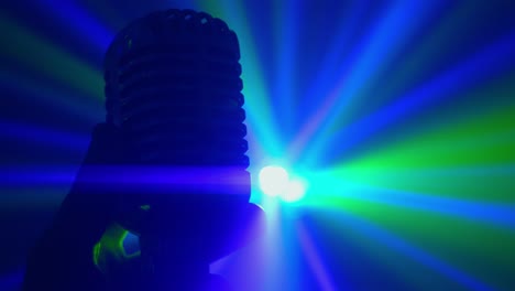 micrófono vintage con luces de discoteca en el escenario. actuación en vivo o concepto de karaoke.