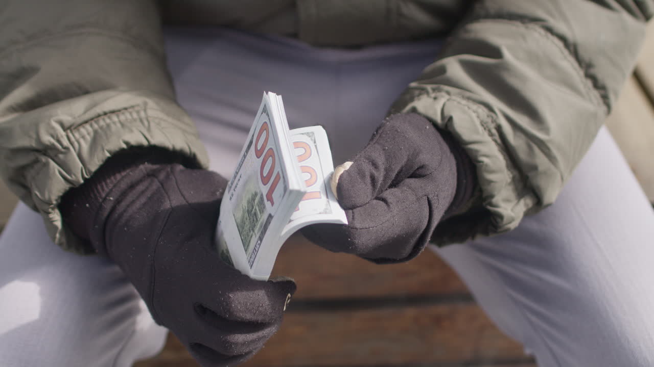 Close up on man&rsquo;s hands checking a pile of USD cash