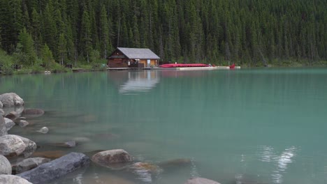 Boathouse-in-Lake-Louise-with-a-leafy-forest-behind