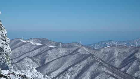 모나파크에서 볼 때, 눈 인 다이리온 산맥의 발완산 산, 은 하늘의 날에 산꼭대기에 거대한 풍력 터빈 농장이 있는 계곡, 평창군, 강원도, 남한