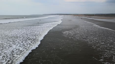 westward ho beach devon drone flying along huge beach surfers in background