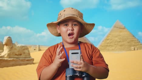 excited boy exploring ancient egypt with smartphone and binoculars