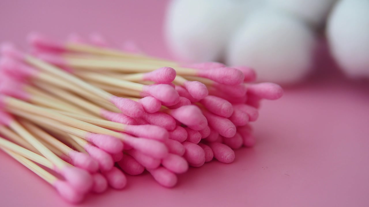 Pink Cotton Swabs with Wooden Sticks on a Pink Background