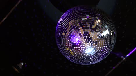 Mirror-disco-ball-hanging-from-the-ceiling-is-rotating