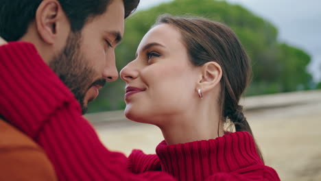 en primer plano, los amantes felices se besan en la naturaleza. un retrato vertical de una pareja enamorada.