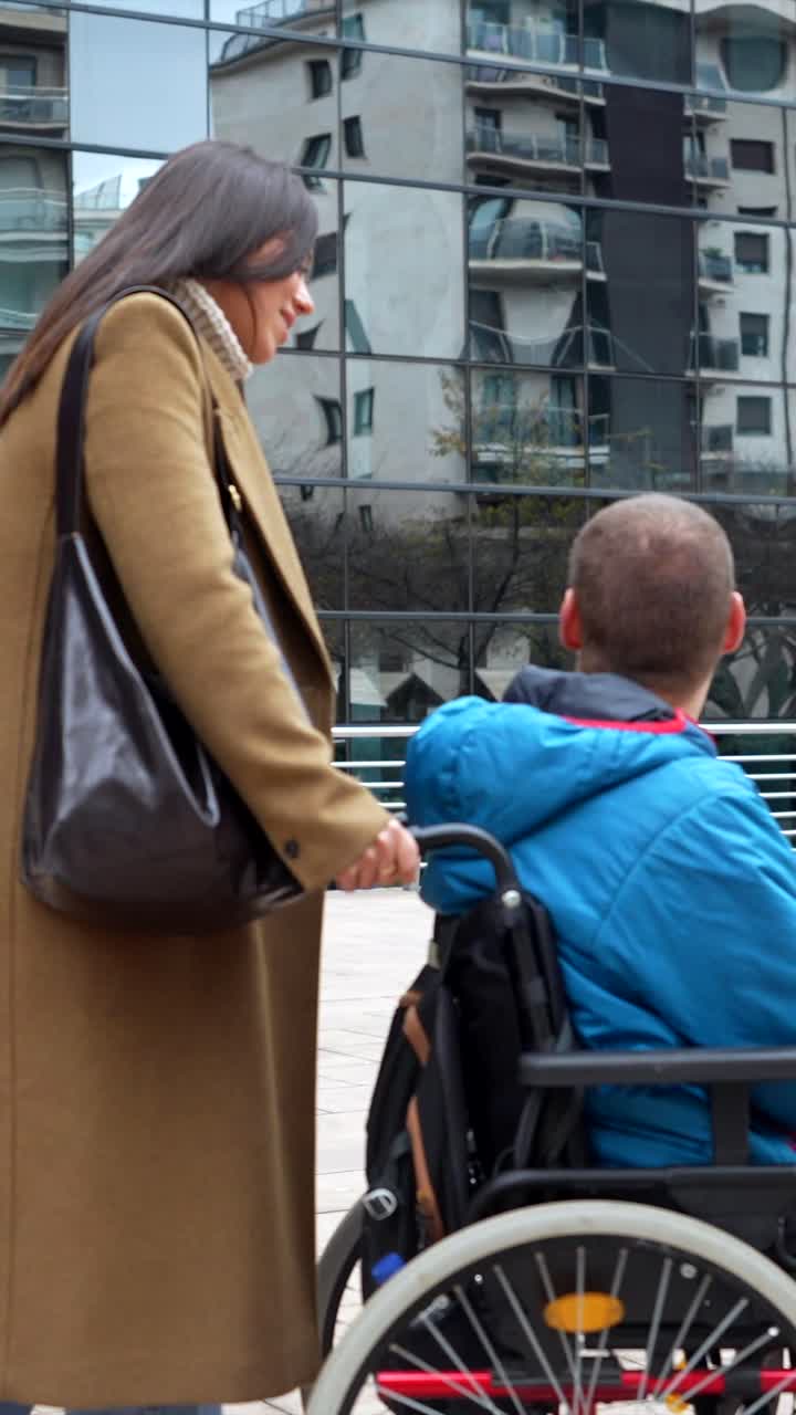 Assistenza in città: donna che spinge un uomo su una sedia a rotelle