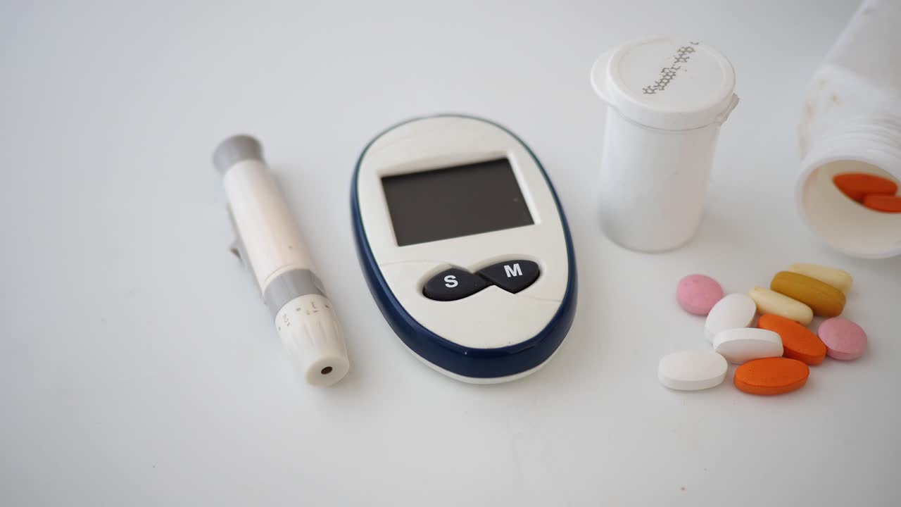 Glucose Meter, Lancing Device, and Pills on White Background
