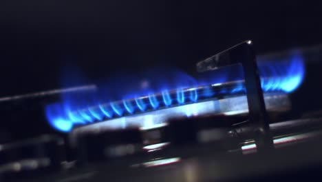 close up viewed from below of igniting a gas cooker with a bright blue flame