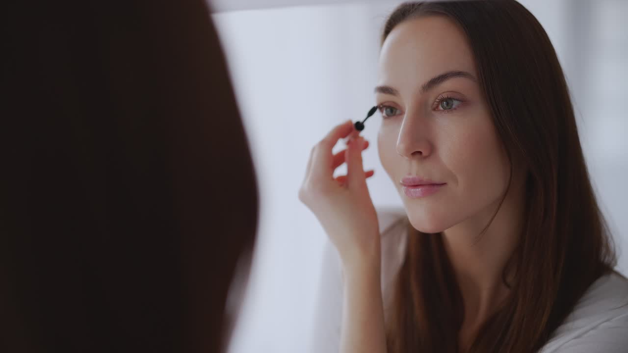 거울 앞 에서 마스카라 를 쓰는 여자