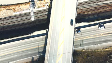 hyper-lapse-bird's-eye-view-zoom-out-drone-shot-of-Cross-Bridge-of-the-Highway-1-and-Yellowhead-Highway-in-Kamloops-BC-Canada-with-train-tracks-in-the-background-and-moving-light-rays-on-the-street