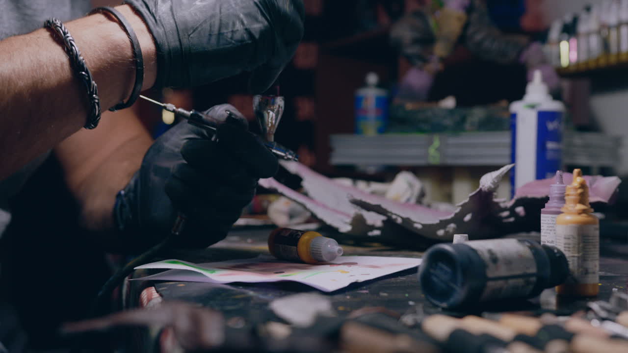 officina di pittura uomo dipinge mescolando vernice in airbrush medio slow motion shot