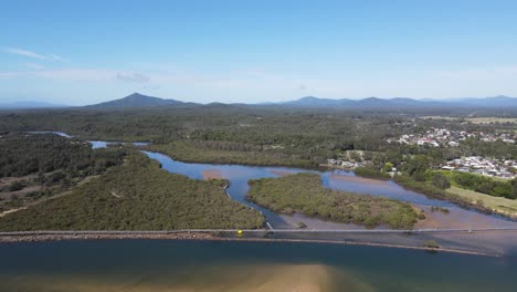 Luftaufnahmen-Des-Urunga-Boardwalk-Mit-Atemberaubender-Aussicht-Auf-Die-Great-Dividing-Range-Und-Die-Gemeinde-Urunga