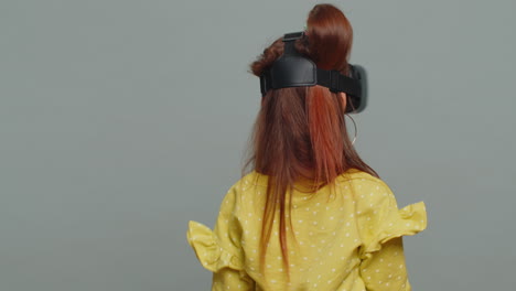child kid girl using headset helmet app to play simulation game watching virtual reality 3d video