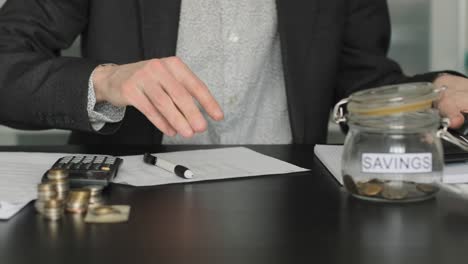 man taking money out of a wallet on the desk