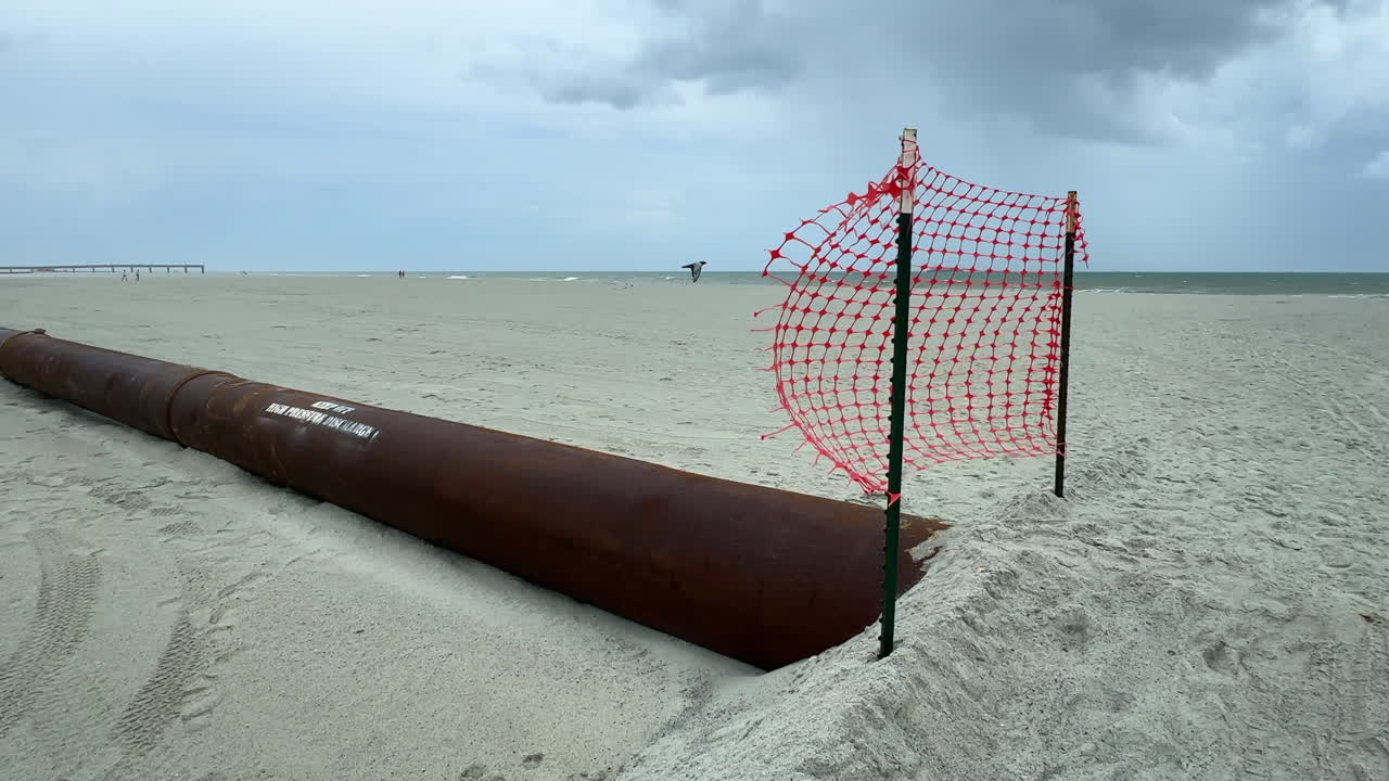 Beach Pipeline Construction Under Cloudy Sky