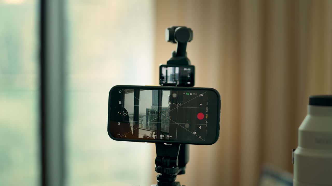 A close-up view of a smartphone used as a camera monitor to adjust settings, capturing a blurred city background. Ideal for tech tutorials or gadget enthusiasts