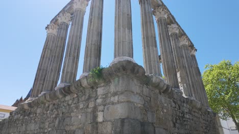 ruined roman temple columns under blue sky in évora portugal