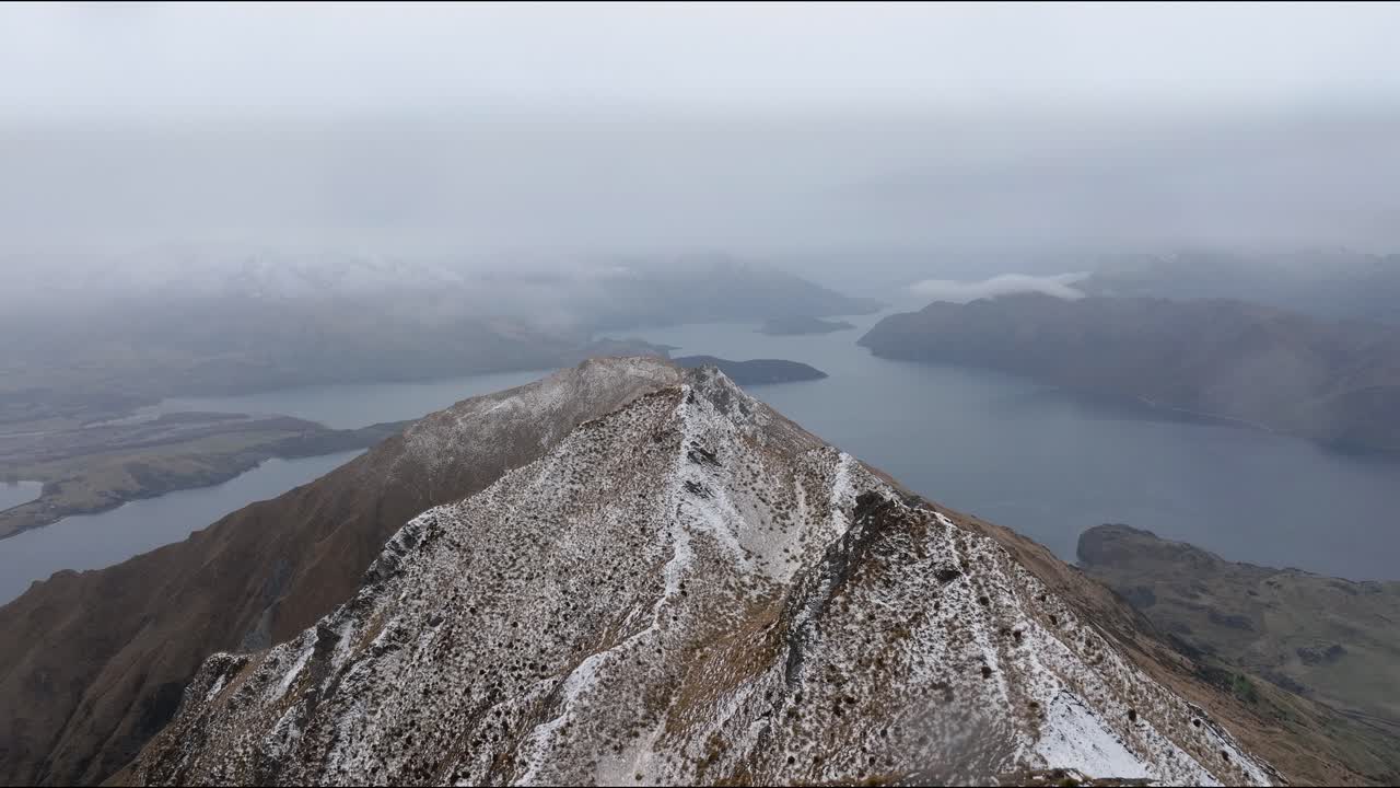 los excursionistas llegan a la cumbre de roy's peak en nueva zelanda, que ofrece vistas impresionantes de las montañas y valles circundantes.