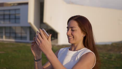una hermosa mujer joven de cabello largo tomando selfies durante la puesta de sol.