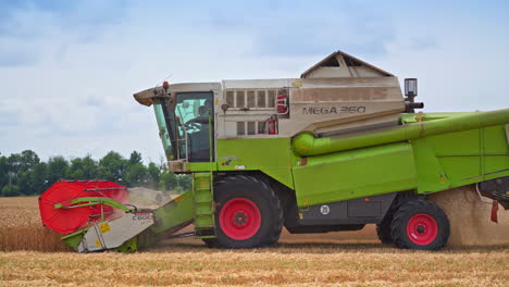 the harvester collects the finished wheat. agricultural machines working in farmland during harvesting