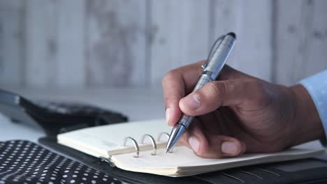 person writing in a notebook