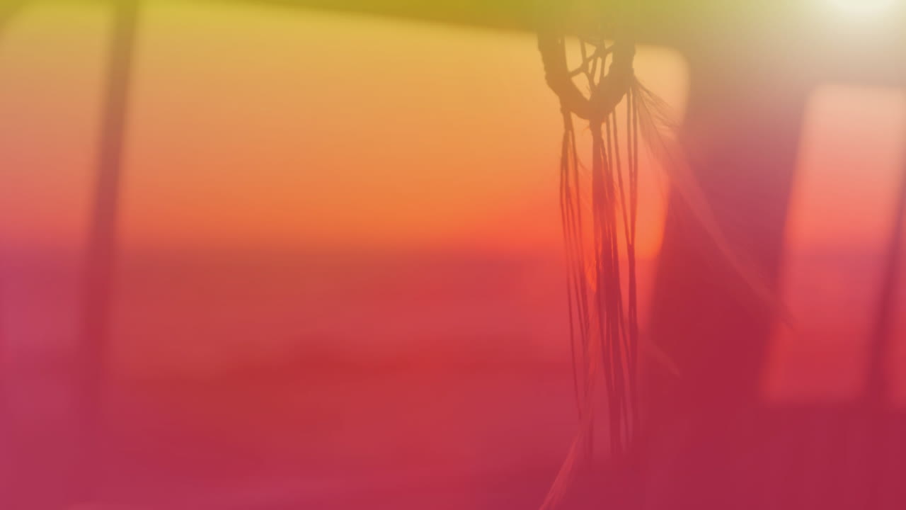 꿈을 잡는 사람의 애니메이션이 바람에 움직이고 노란색에서  ⁇ 은색으로 배경에 해가 지고 있습니다.