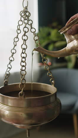 water being poured into a hanging pot