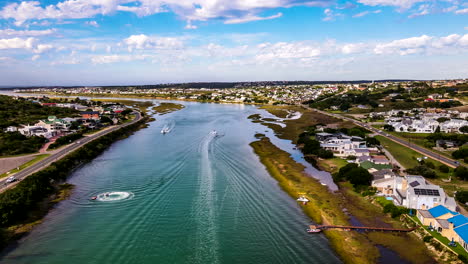 drone hyperlapse over goukou estuarine river with leisure motorboats, still bay