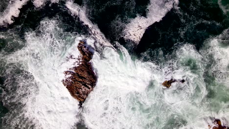 Moody-top-down-aerial-seascape-view-of-Atlantic-ocean-waves-crashing-into-rocks