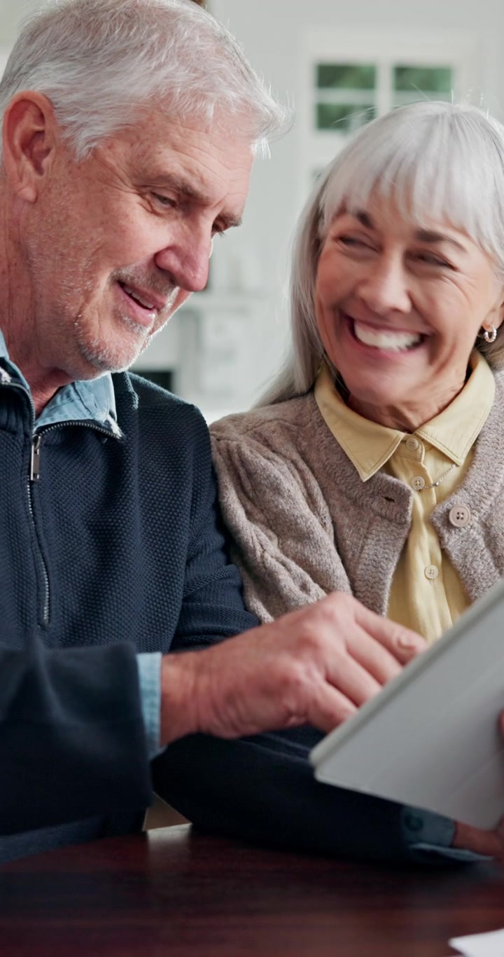 Casal de Idosos Feliz Usando Tablet Juntos em Casa