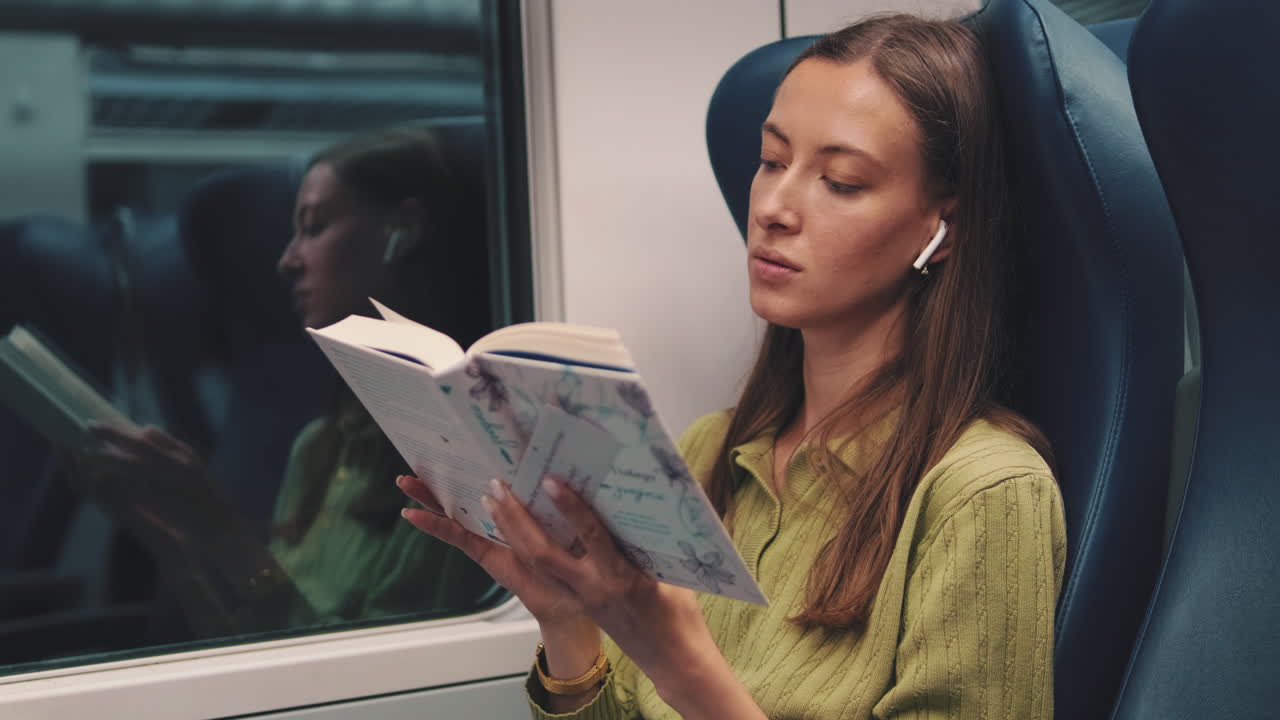 Une femme qui lit un livre dans un train.