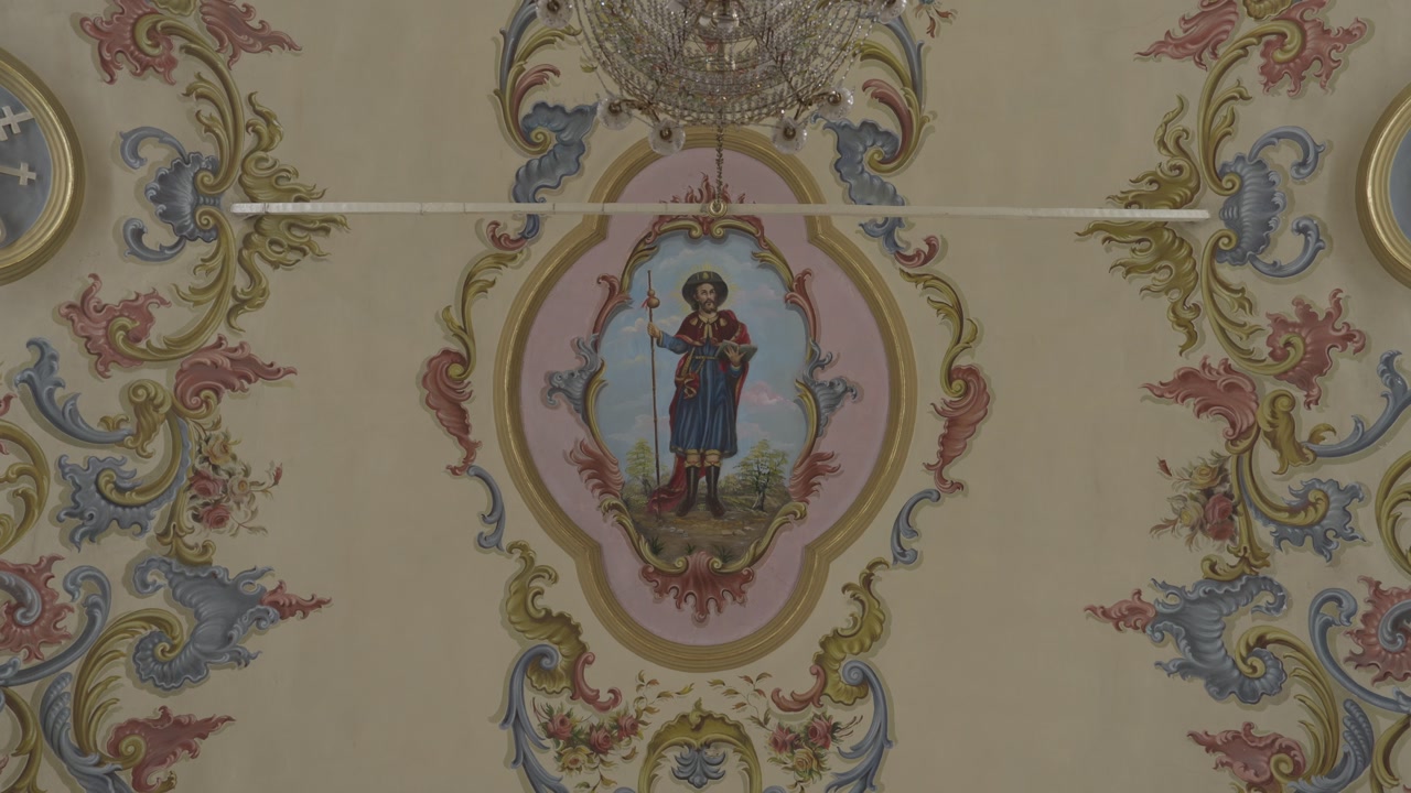 Close up view of religious fresco art and classical patterns on a historic cathedral ceiling.