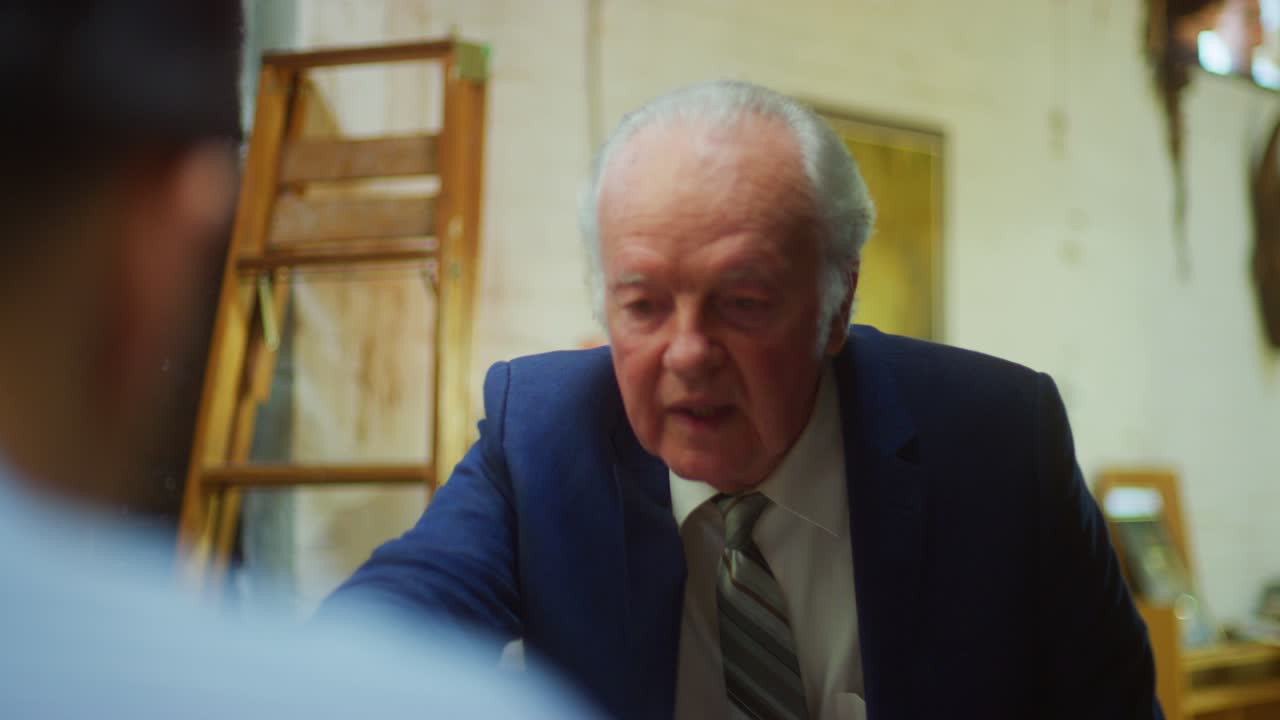 Due uomini esaminano documenti durante una riunione di lavoro.