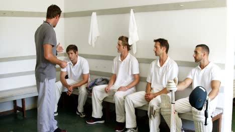 coach interacting with cricket players