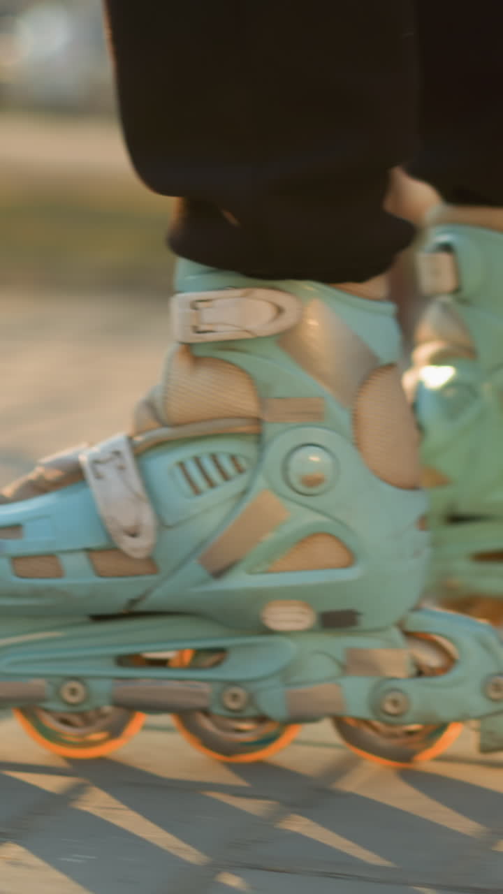 A close-up shot capturing a person s feet wearing rollerblades, smoothly gliding along a paved path in a park during sunset