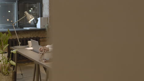 serious american male employee drinking coffee from a mug while working on computer in the office