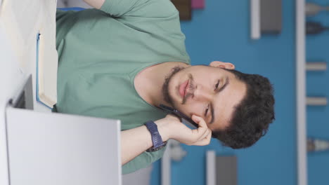 Vertical-video-of-Male-Student-Talking-Unhappy-On-The-Phone.