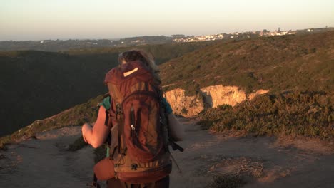 active female backpacker walking on footpath