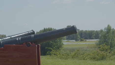 Medium-shot-of-old-cannons-overlooking-typical-Dutch-landscape