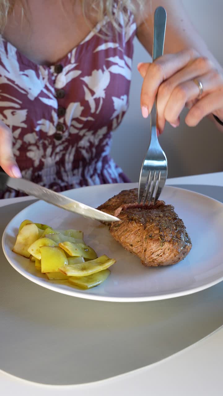 Vertical Shot, Woman Slicing Rare Cooked Steak With Roasted Peppers On Plate
