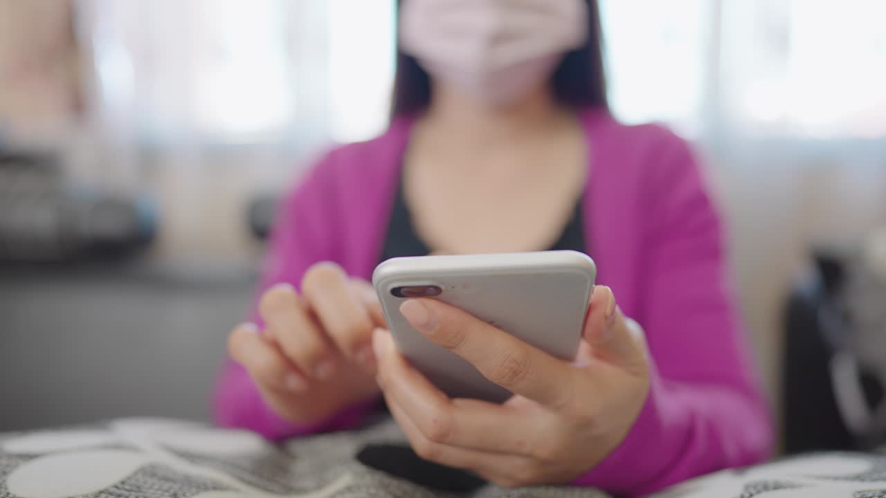 una mujer en primer plano sentada en un sofá sosteniendo un teléfono inteligente para comprar en línea en casa