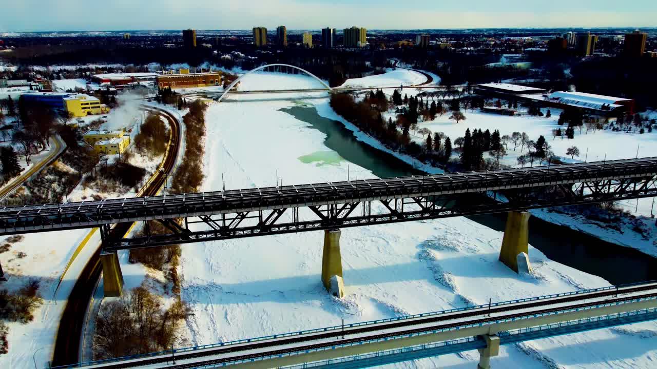 tarde de invierno sobrevuelo aéreo caída rodante vista de pájaro sobre puentes de transporte público alto nivel y blanco moderno walter dale norte saskatchewan río entre victoria kinsmen park blu3-4