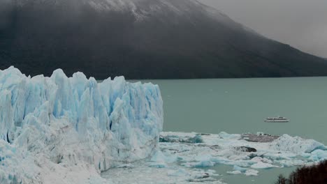 a boat sits near the side of a giant glacier in patagonia argentina