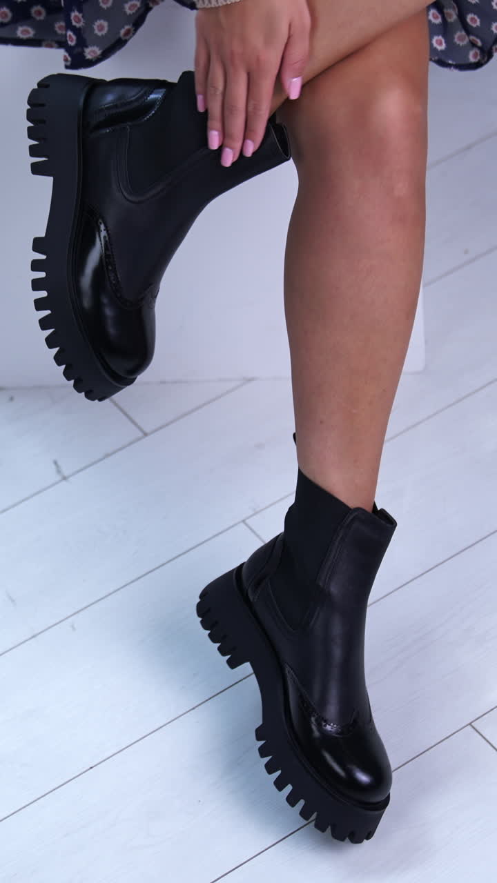 Feet of woman posing shoes. Girl fit legs in black boots. Vertical video